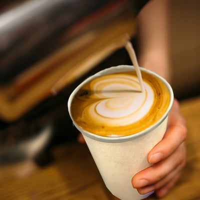 Latte being poured into 16oz compostable hot cup.