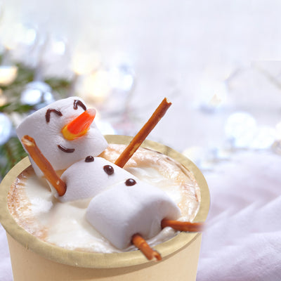 A 16oz compostable hot cup filled with hot chocolate, topped with snowman.