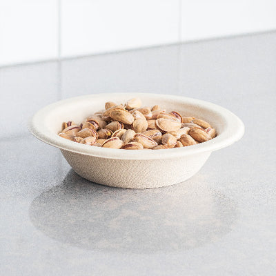 Assorted nuts in a compostable 12 oz bowl placed on a counter.
