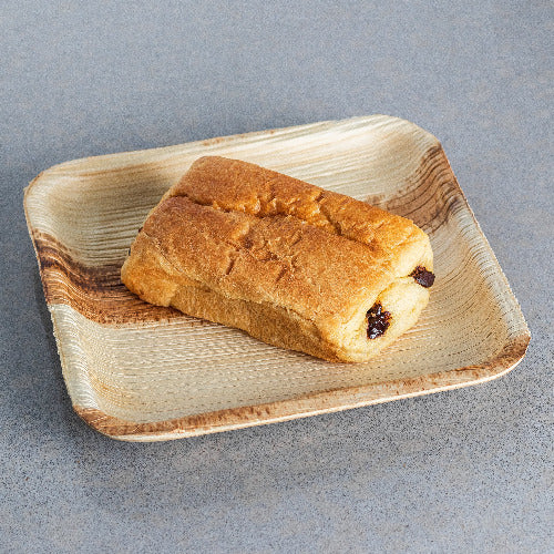 A piece of bread on a Compostable Palm Leaf Plates.